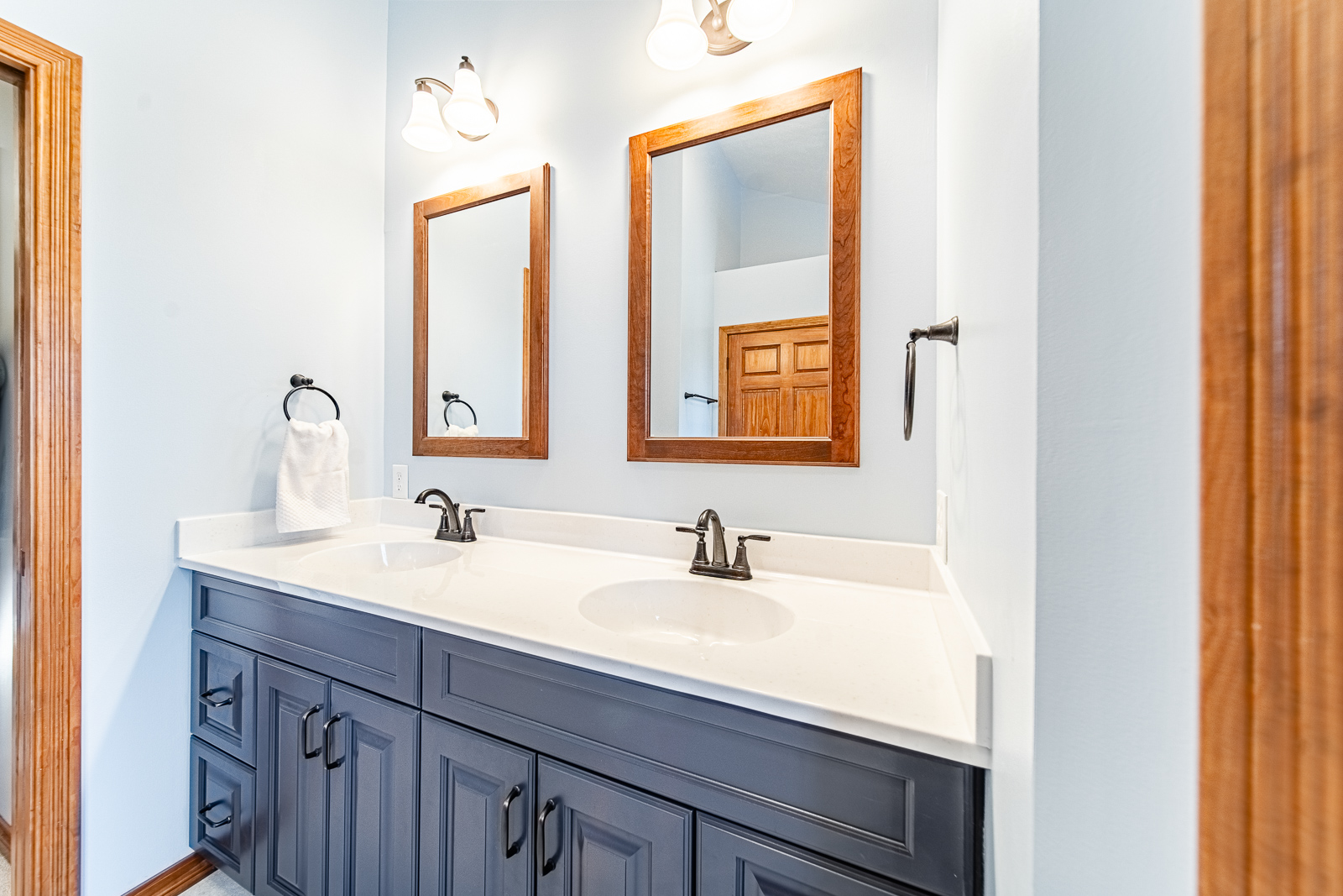 Close-up of vanity details, showing cabinet hardware and mirrors in remodeled space