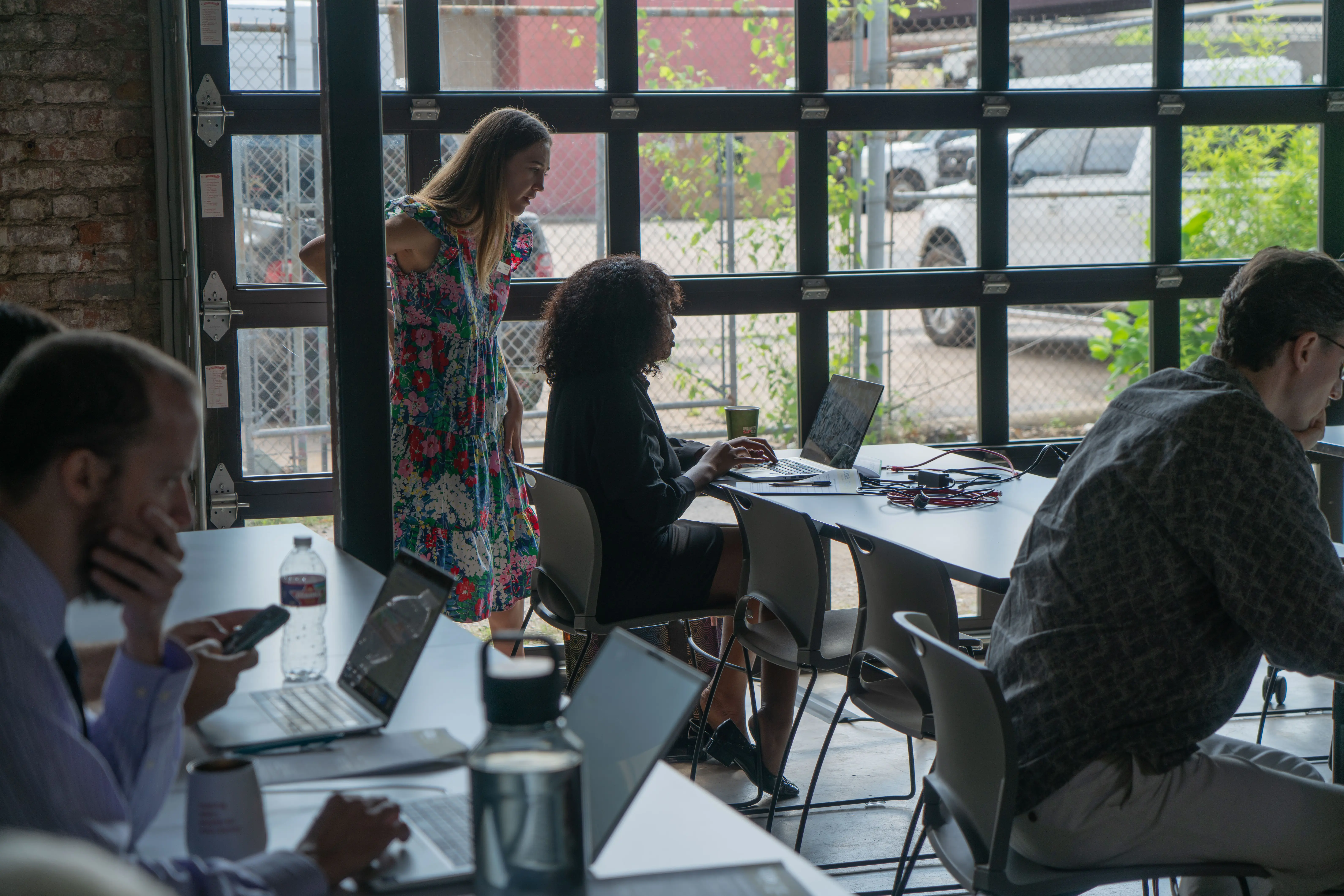 an instructor stands behind a student coding ai prompts during a workshop