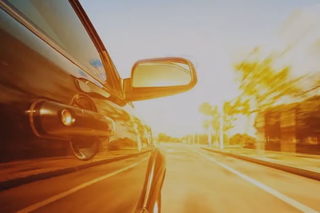 Car driving with speed in a sunny environment