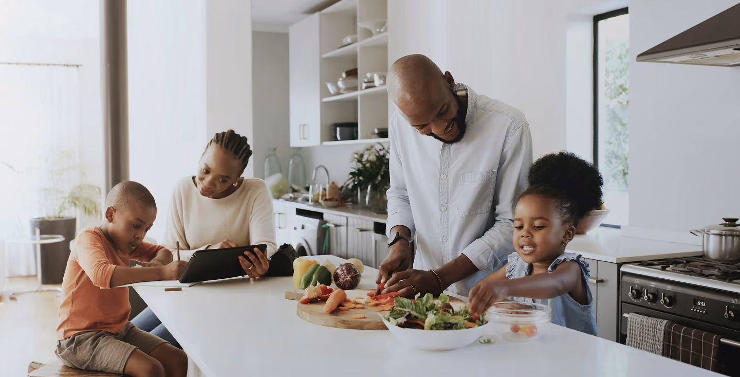family sitting around kitchen table, making dinner