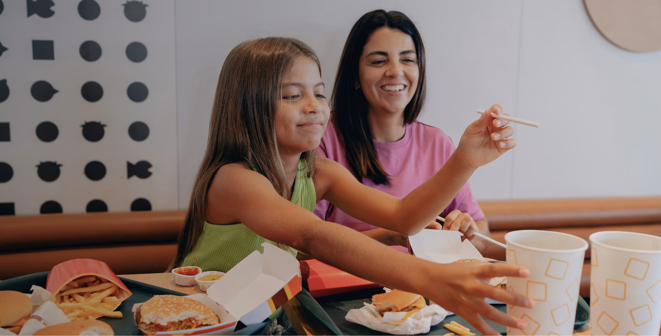mother and daughter eating hamburger and fries