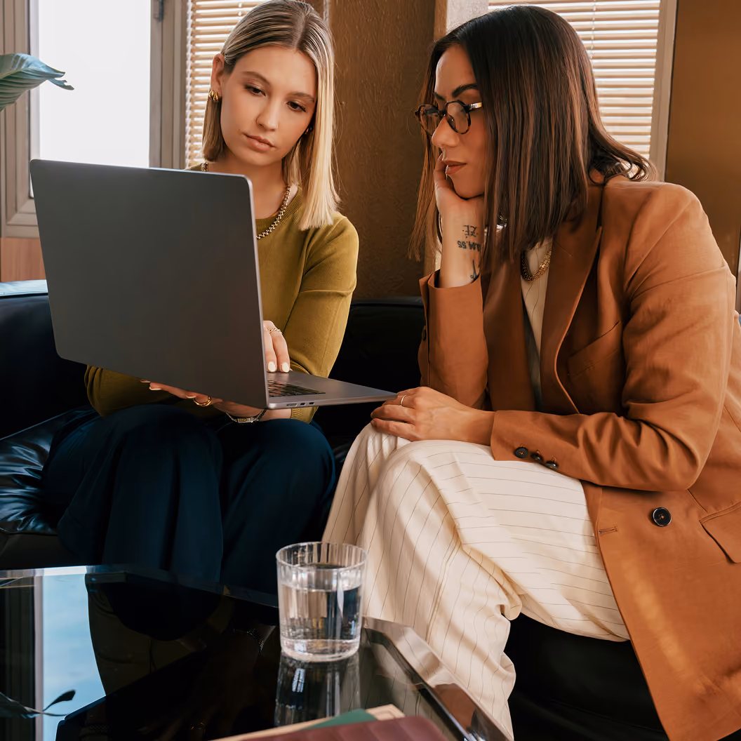 Two colleagues reviewing Attain purchase data on a laptop