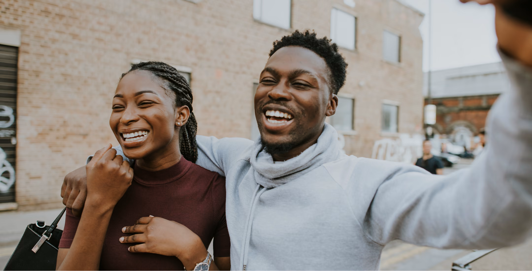 man and woman walking outside, smiling