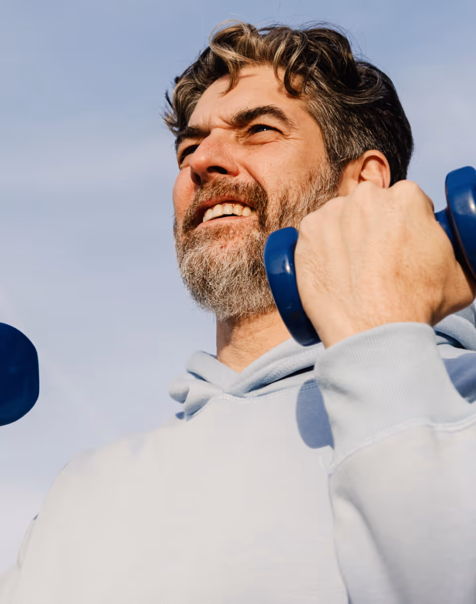 Man strength training outdoors as part of a long-term weight-management plan.