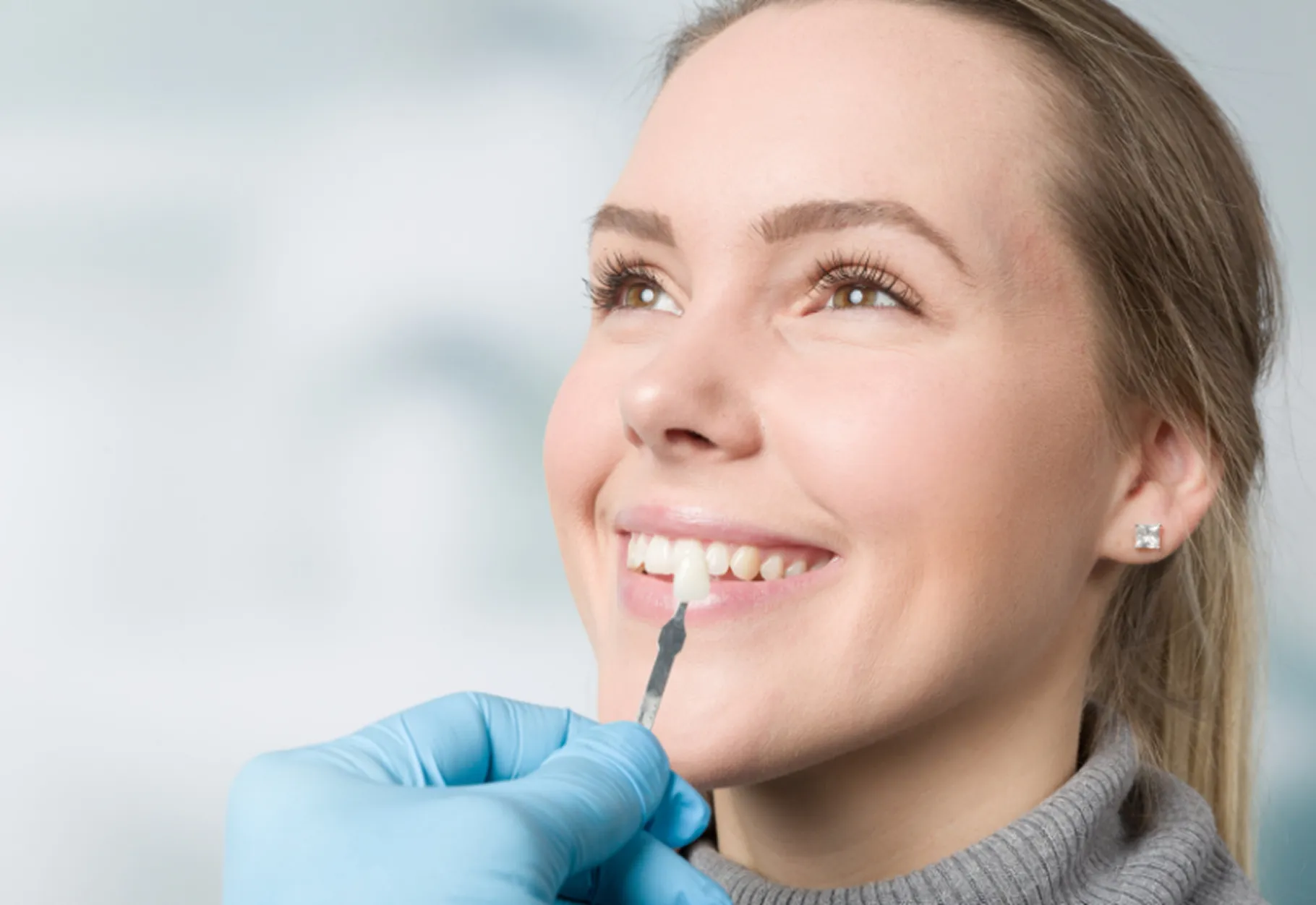 Dentist matches the colour of the veneer to the patient’s natural teeth at Arc Dental Surrey Hills.