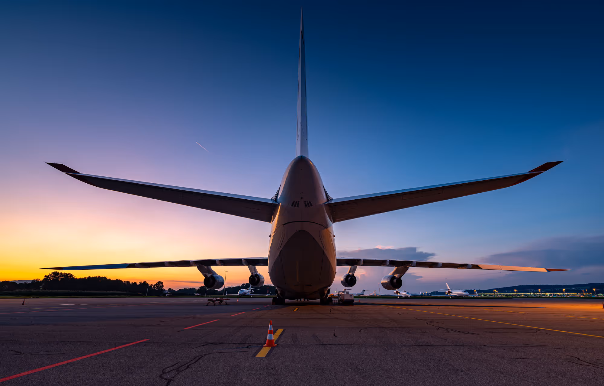 Rückansicht eines großen Flugzeugs auf dem Rollfeld bei Sonnenuntergang.