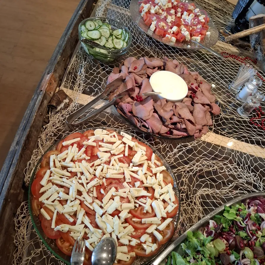 Pitopalvelun tarjoilupöytä: pizzaa, leikkeleitä ja tuoresalaattia
