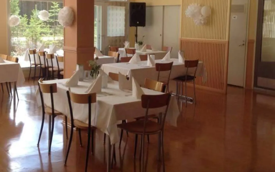 Ravintola Hiekkalahden suuri sali katettuna, suuret ikkunat ja mäntymetsää