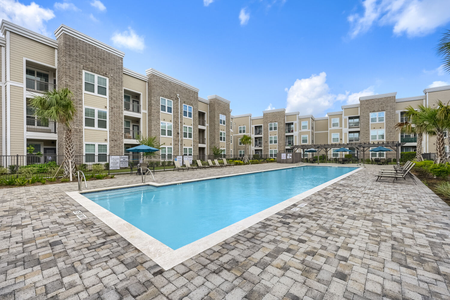 View of pool deck, chairs and pergola