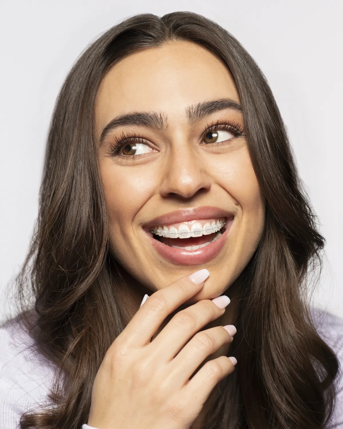 BLANCH | A woman with long brown hair and a white shirt is smiling.