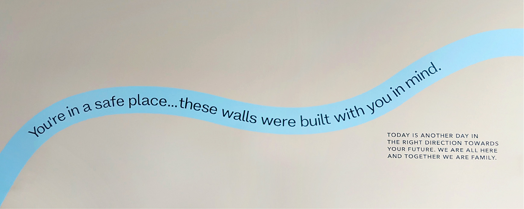 Decorative ribbon wall art reading "you're in a safe place... these walls were built with you in mind."