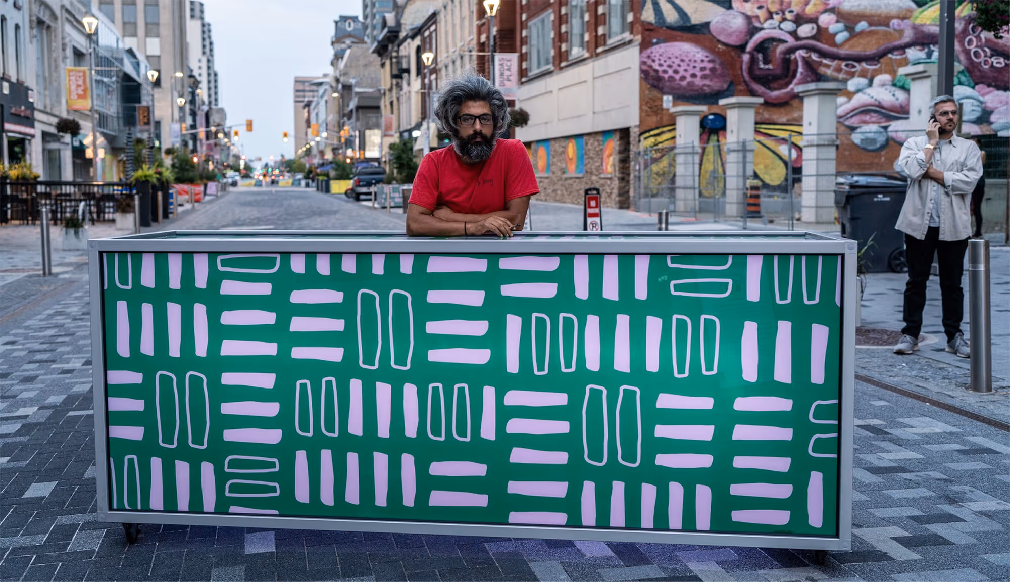 A physical barricade decorated with green and pink pattern, shown blocking the entrance to Dundas Pace in Downtown London Ontario.