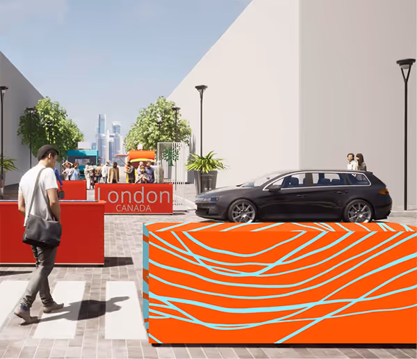 A rectangular barrier located in Downtown London, printed with orange and blue wavy lines.