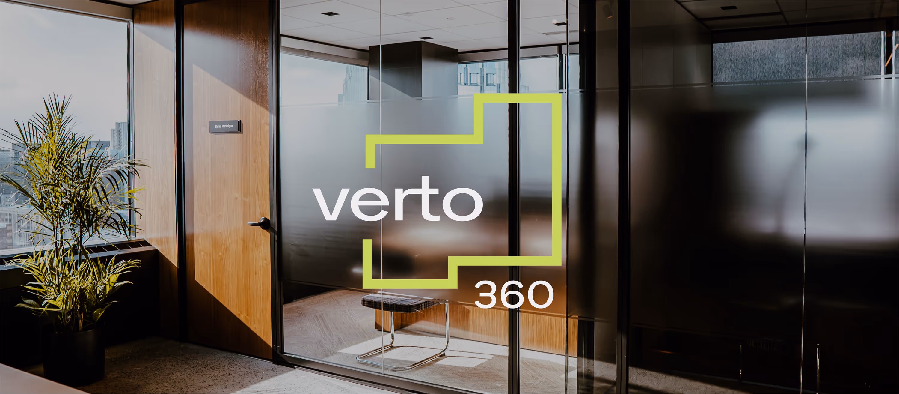Office entrance with glass door =, a wooden wall, and a potted plant by a window. White and green Verto360 logo is overlaid on top.