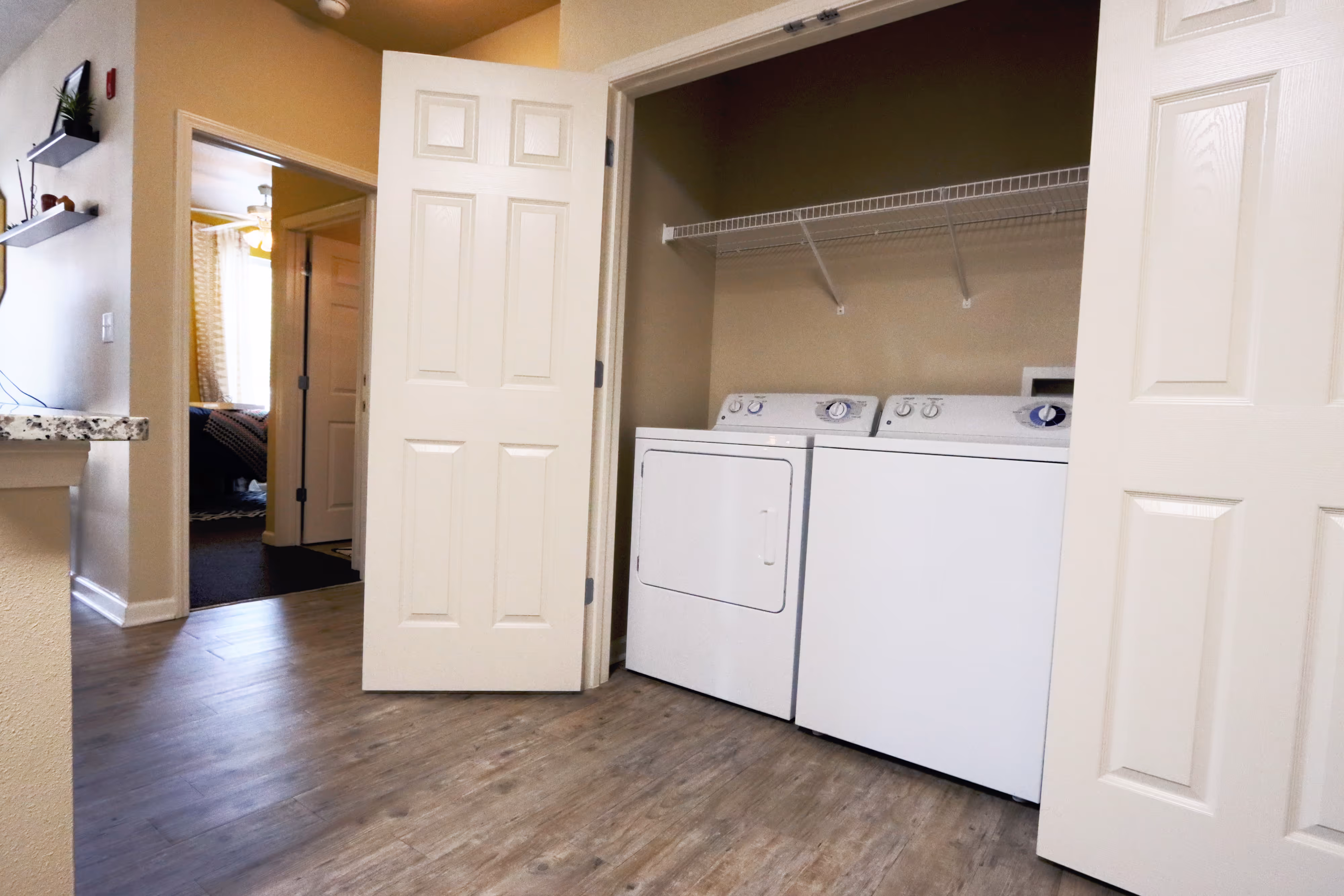 Laundry closet with a full-size washer and dryer in an apartment at Rev Oxford, located off the main living area.