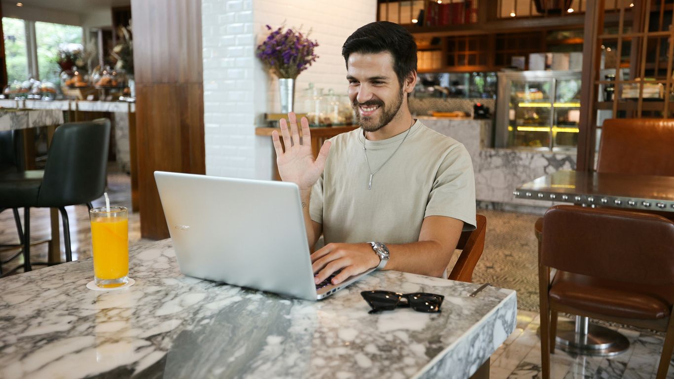 a man sitting at a table using a laptop computer