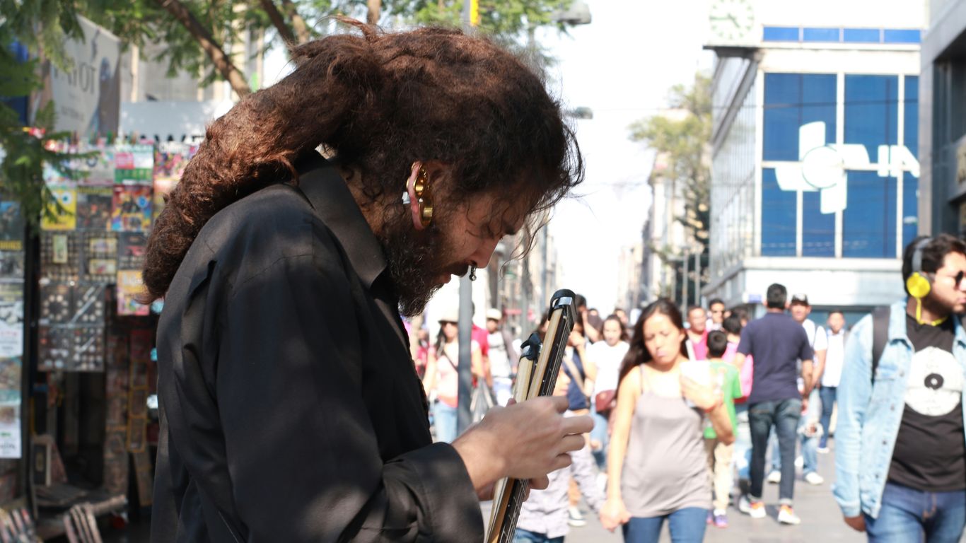 man in black suit playing guitar