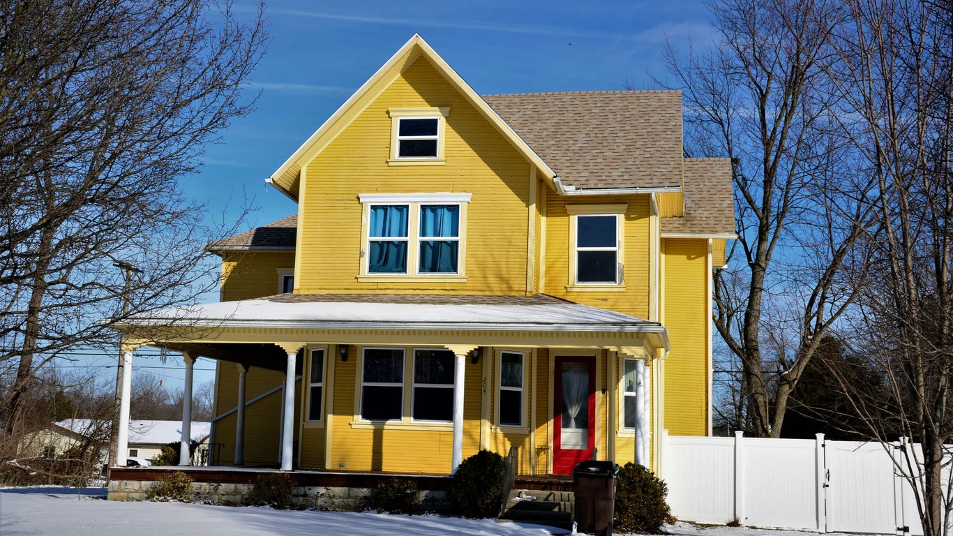 a yellow house with snow on the ground