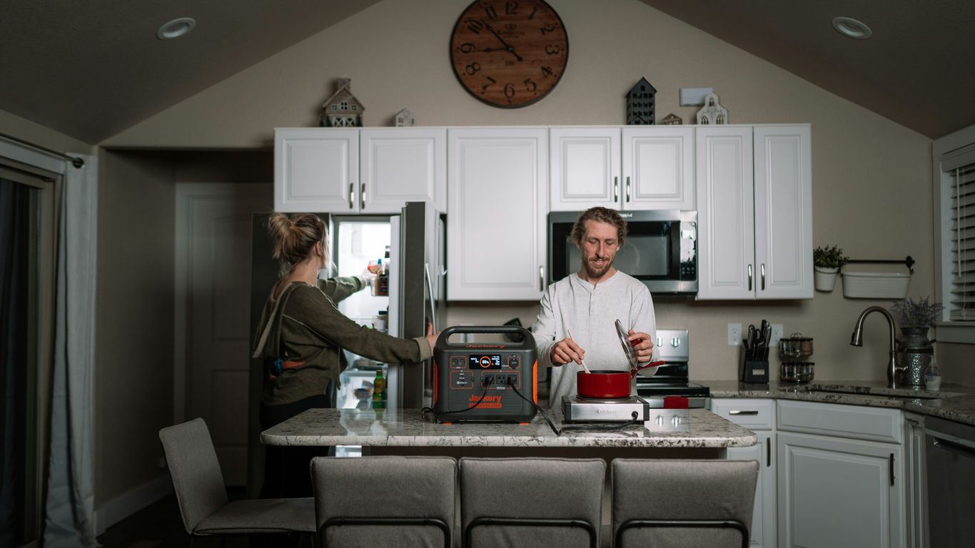 a couple of people stand in a kitchen