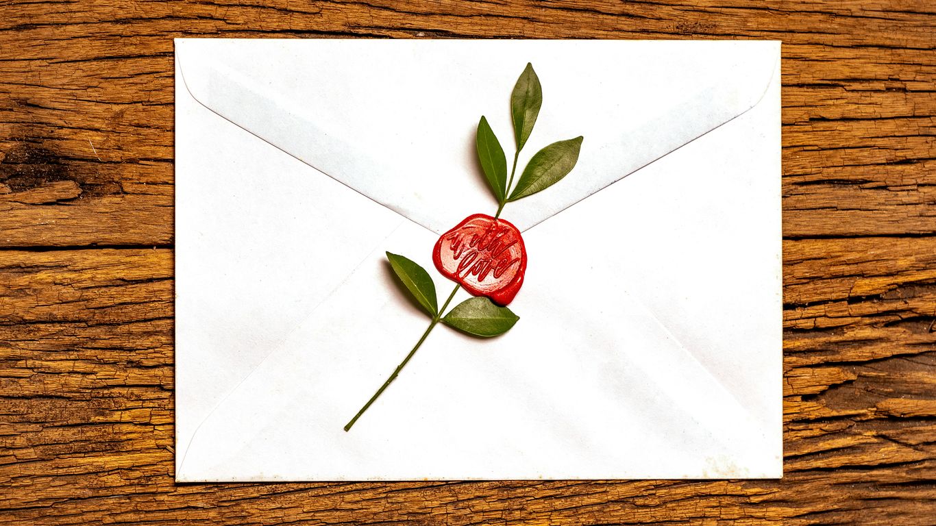 red rose on white envelope