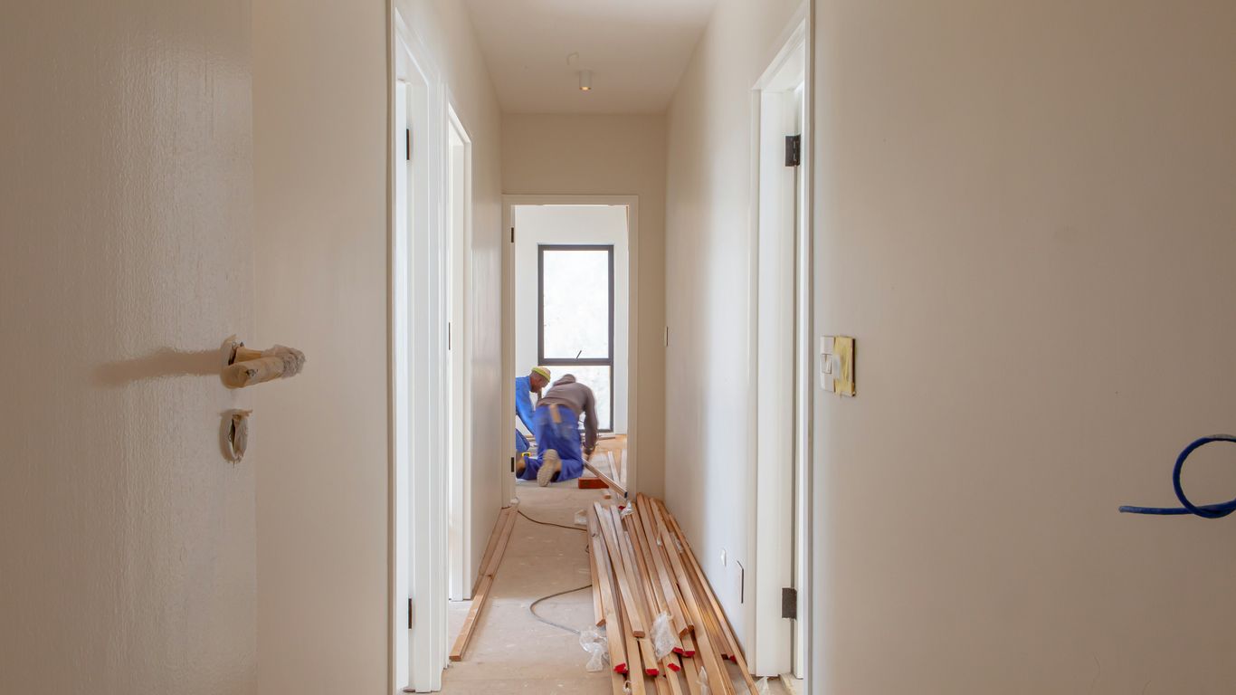 a couple of men working on a house