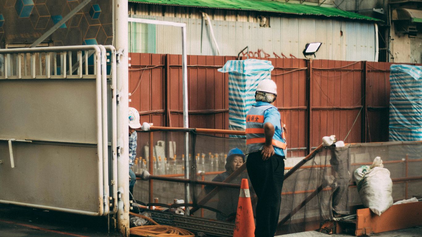 man standing beside traffic cone