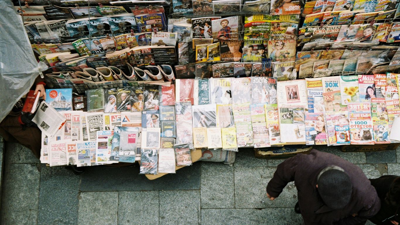 man in black jacket standing on white floor tiles