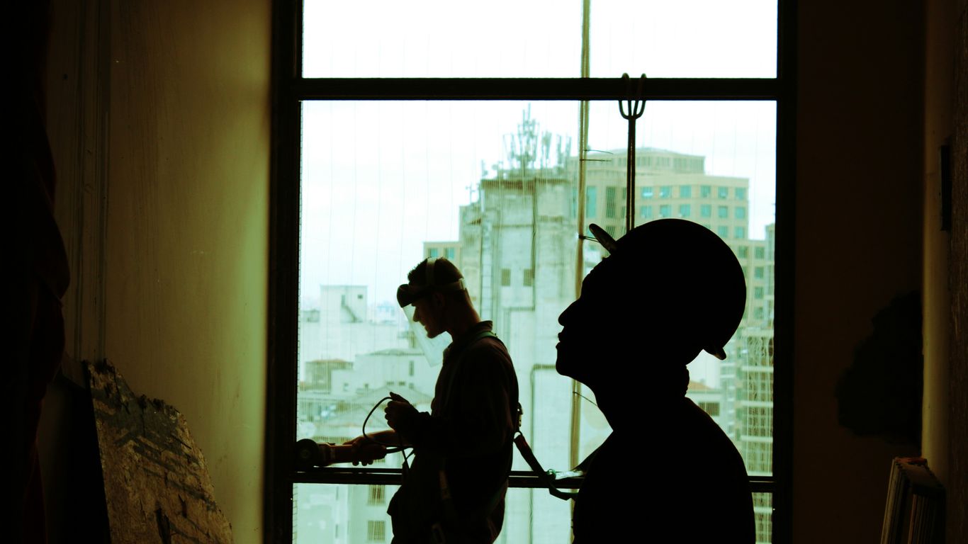two men wearing hard hat standing near clear glass window