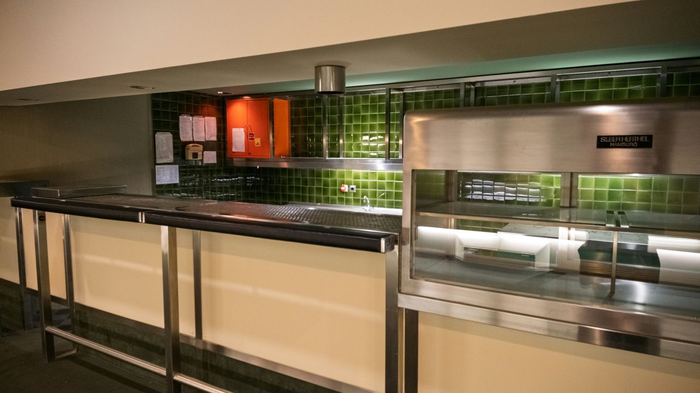 A modern cafeteria serving counter with stainless steel equipment.