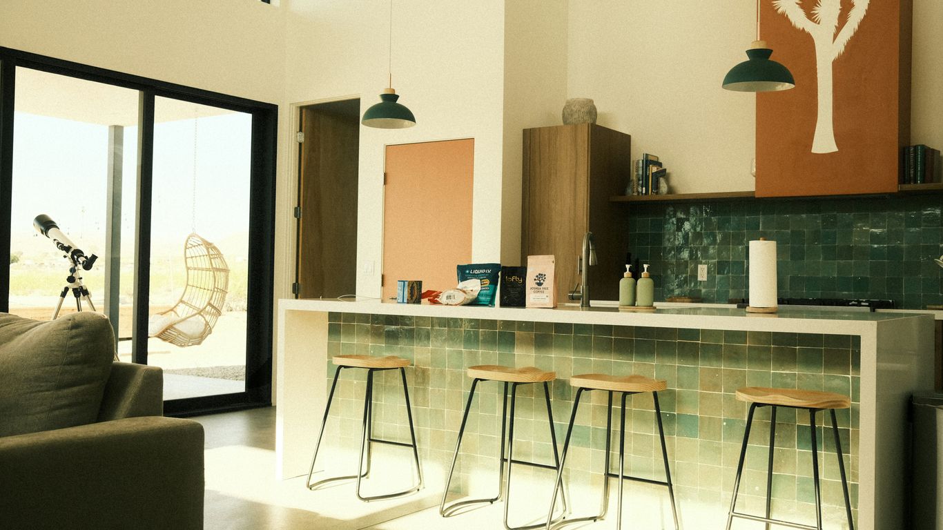 An interior shot shows a modern kitchen and living room.