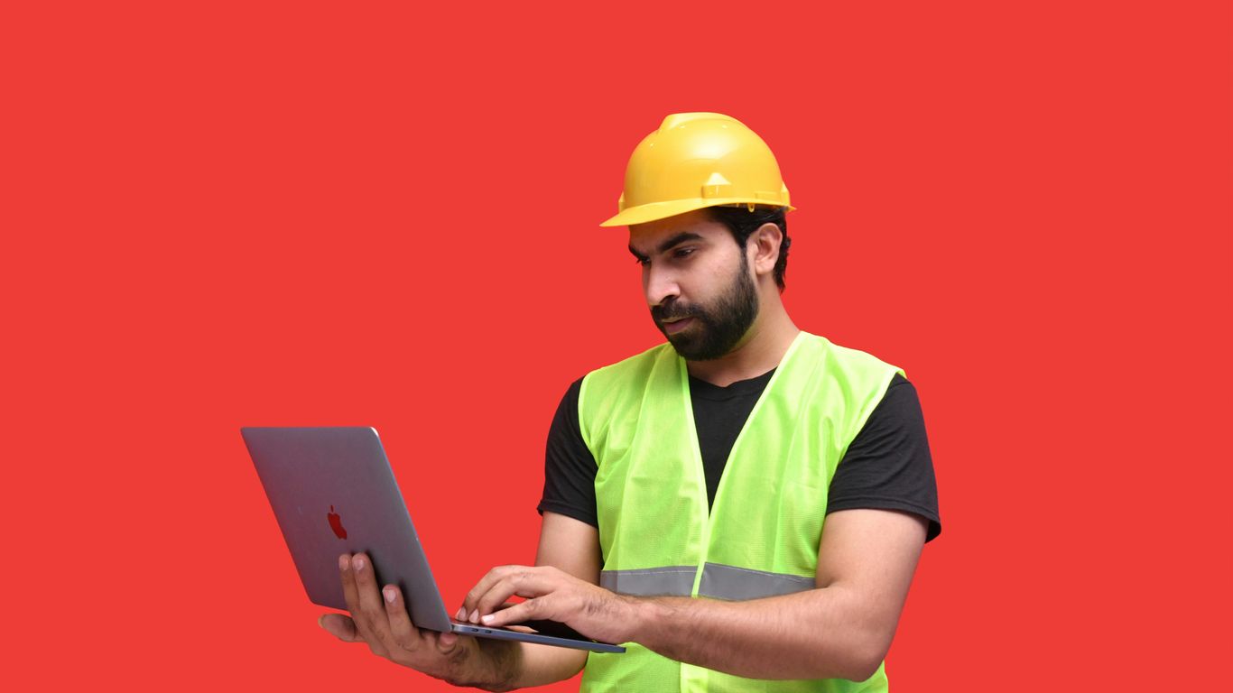 a man in a yellow hard hat holding a tablet