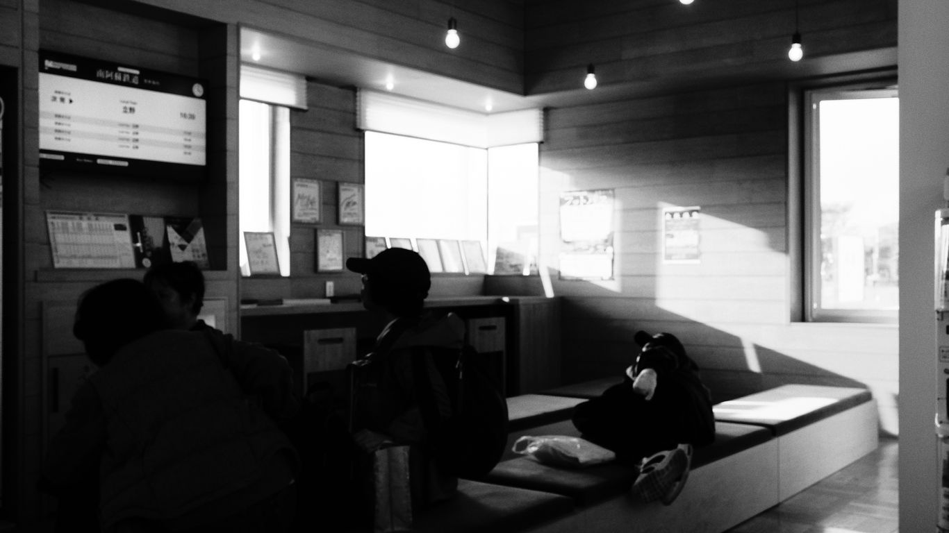 a couple of people sitting on a bench in a room