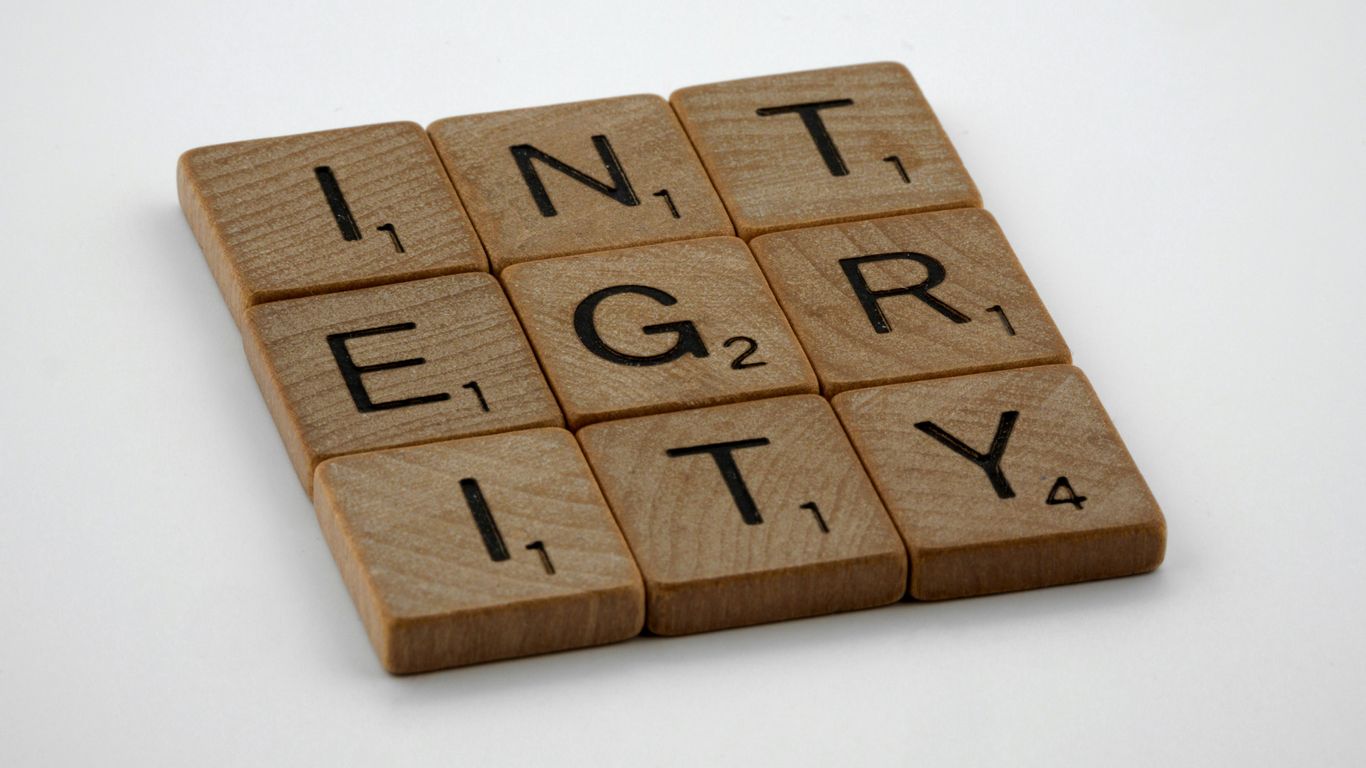 a scrabbled wooden block with the words integr city on it