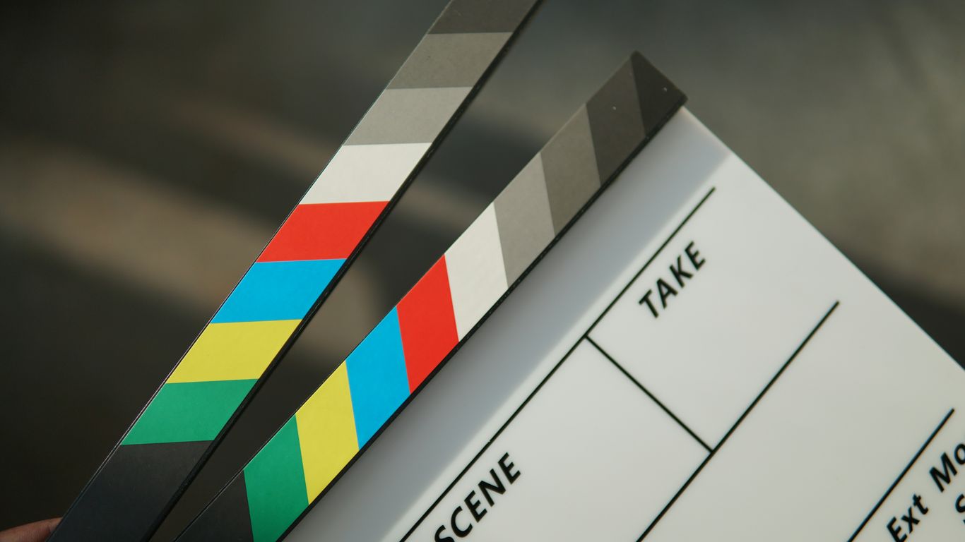 A person holding a clapstick in their hand