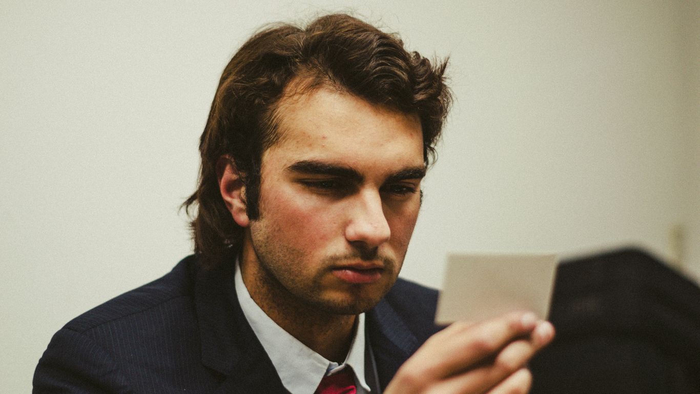 a man in a suit looking at a tablet