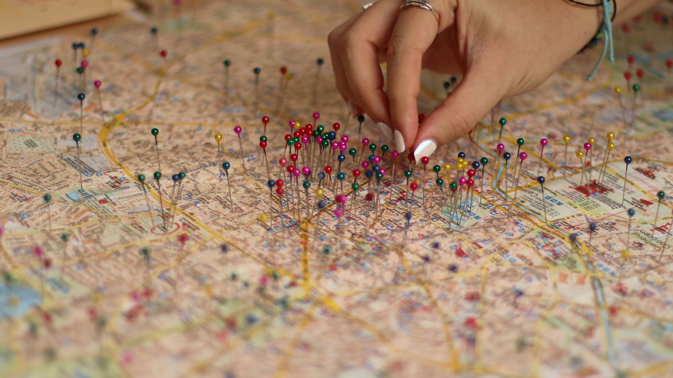 A person is putting pins on a map
