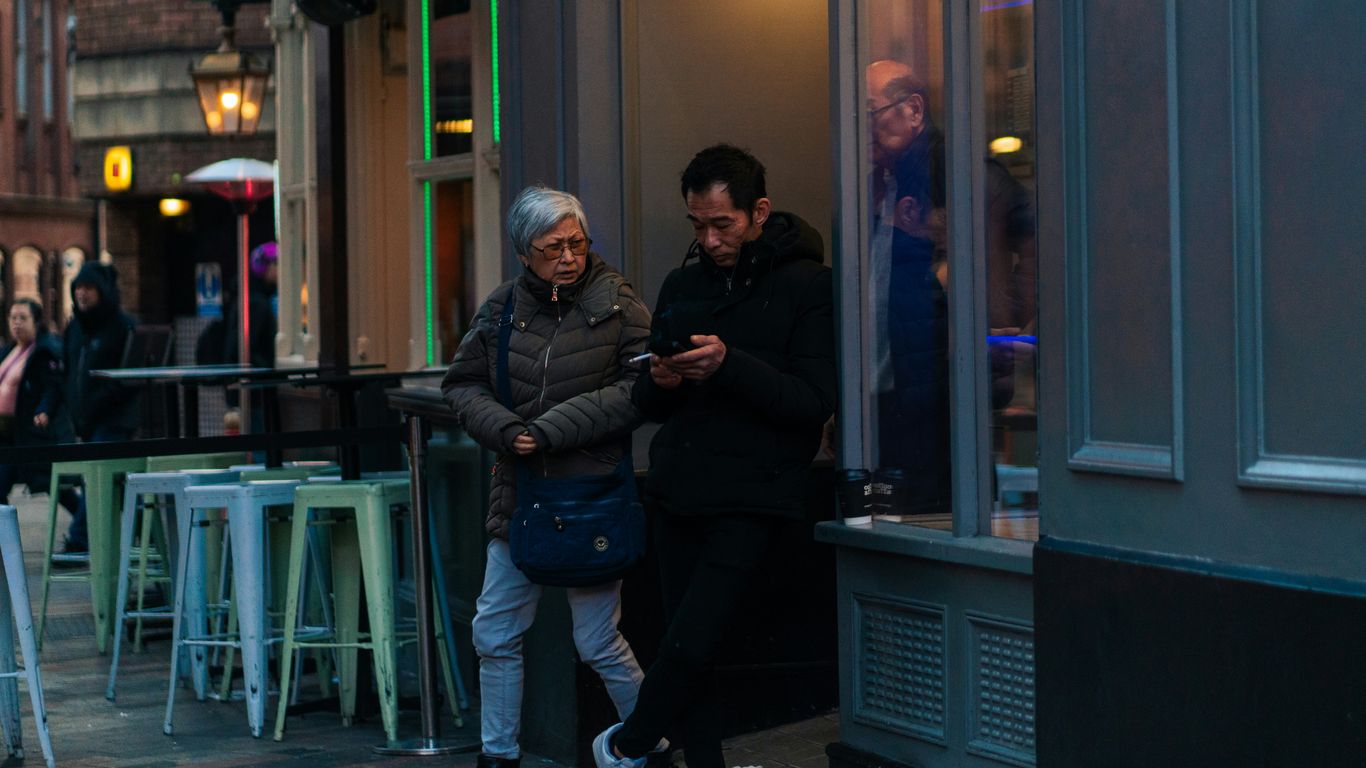 A group of people standing outside of a restaurant