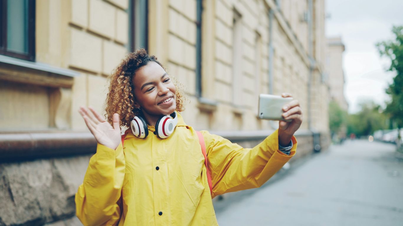 Woman taking a selfie with a smartphone outdoors