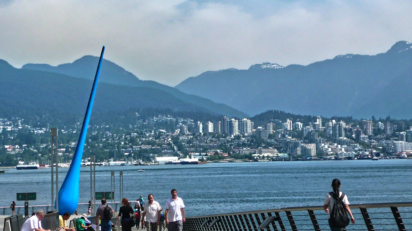 people walking on wooden dock near body of water during daytime
