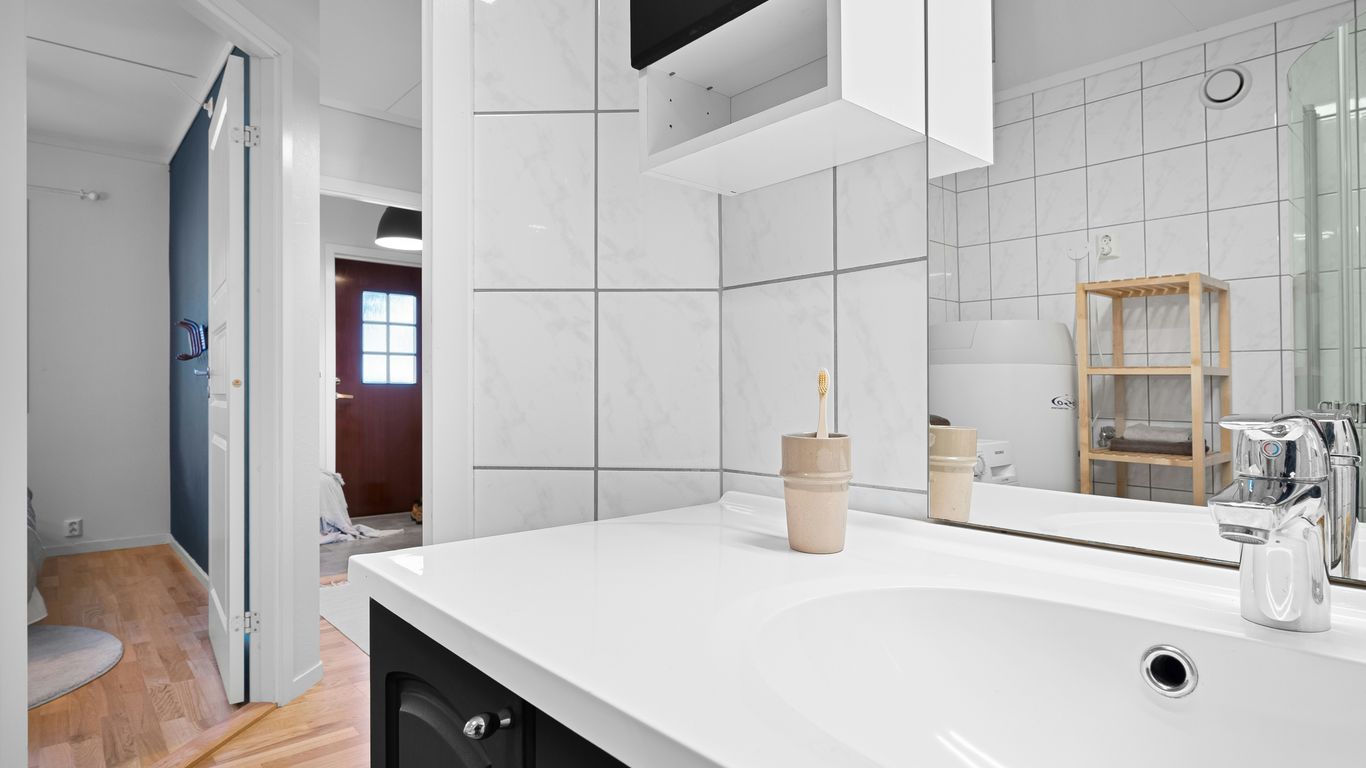 A bathroom with a sink, mirror and toilet