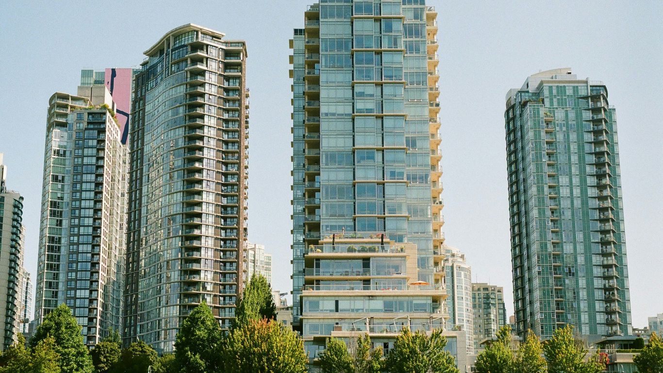 green trees near high rise buildings during daytime