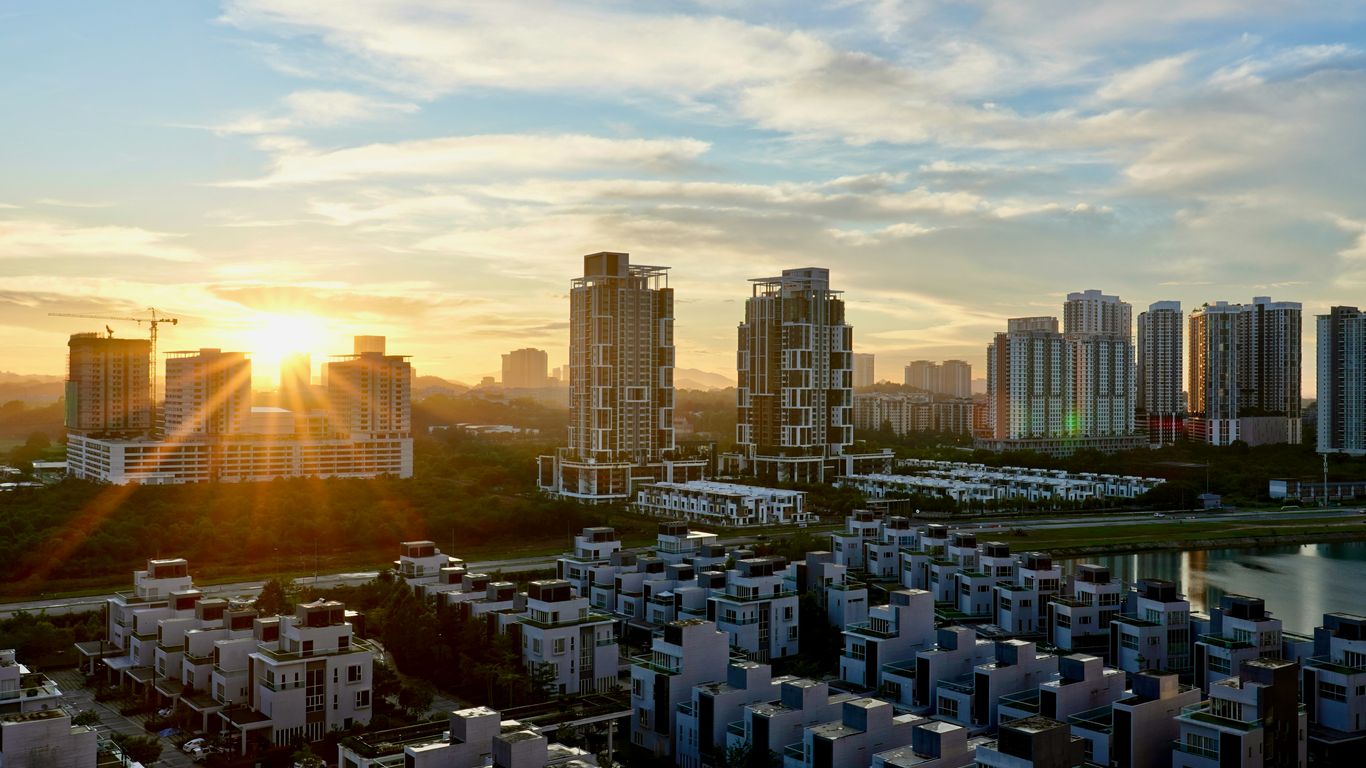 the sun is setting over a city with tall buildings