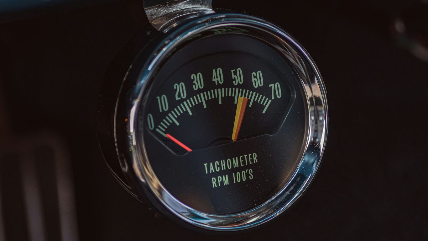 A car dashboard with a speedometer and gauge