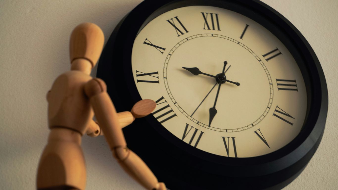 a wooden toy standing next to a clock