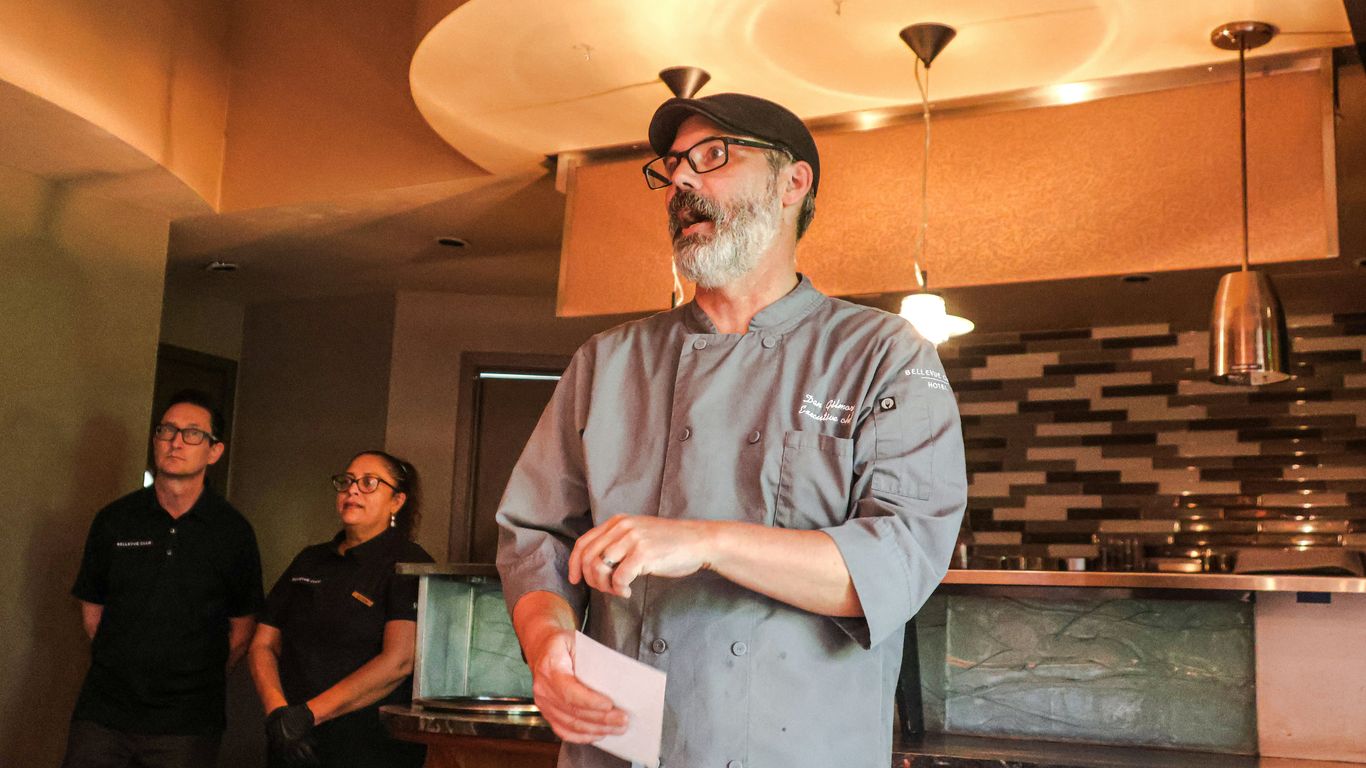 A man standing in a kitchen holding a piece of paper