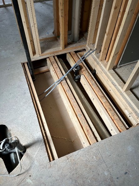 Shower area with subfloor removed in preparation for recessed shower pan.