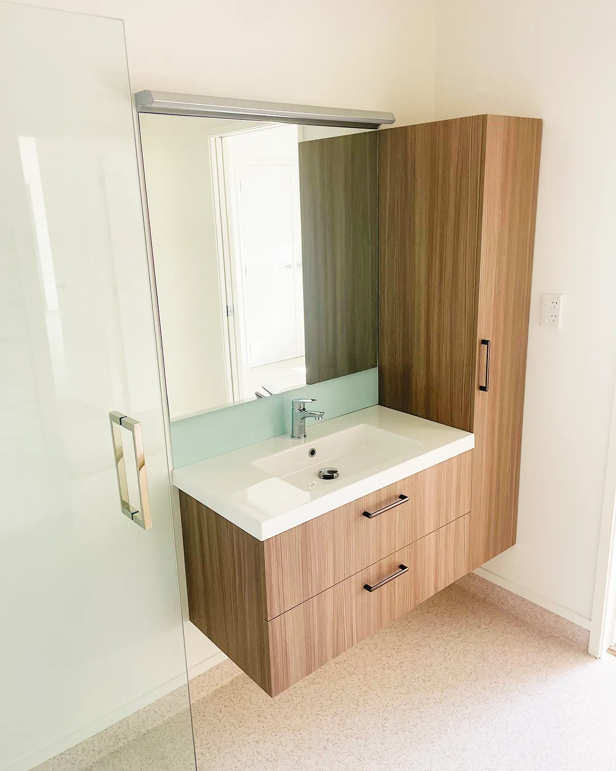 Wall-hung vanity with drawers, mirror and full-height cabinet, leaving the floor clear