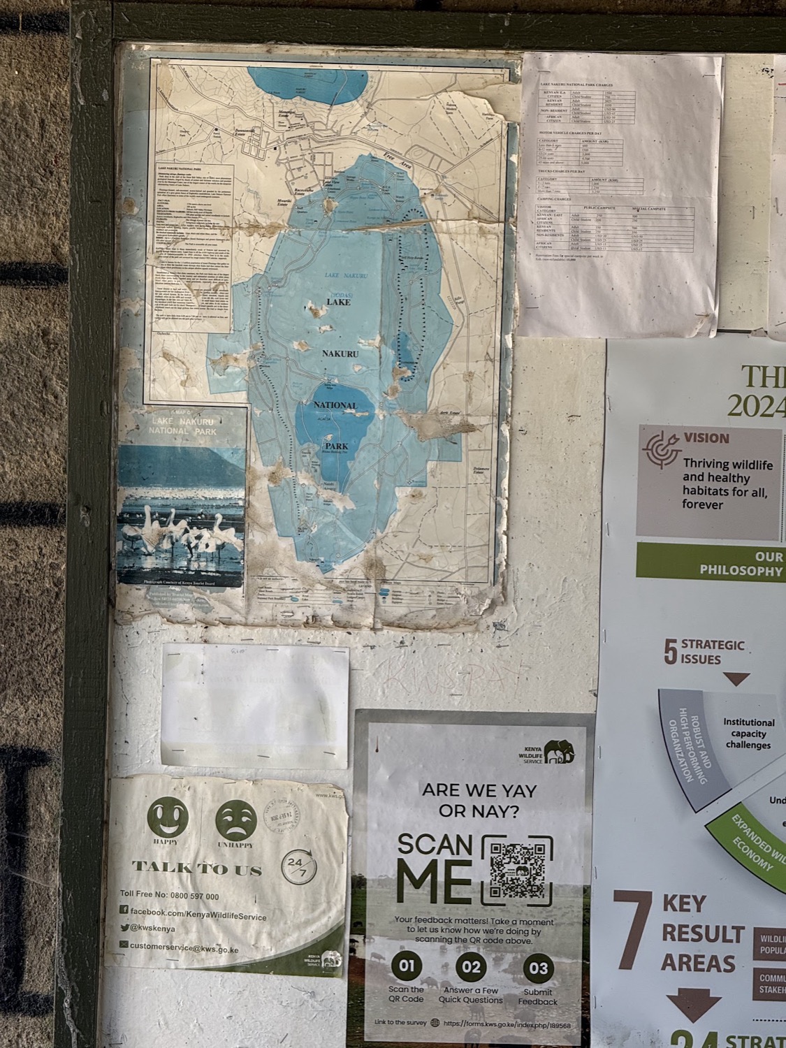 Weathered noticeboard displaying a map and information posters for Lake Nakuru National Park
