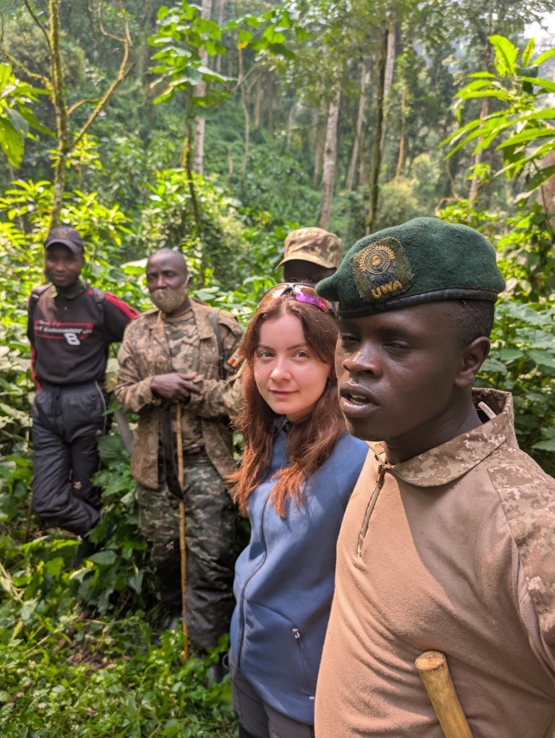 UWA rangers and a tourist pause together on a trail through dense tropical rainforest