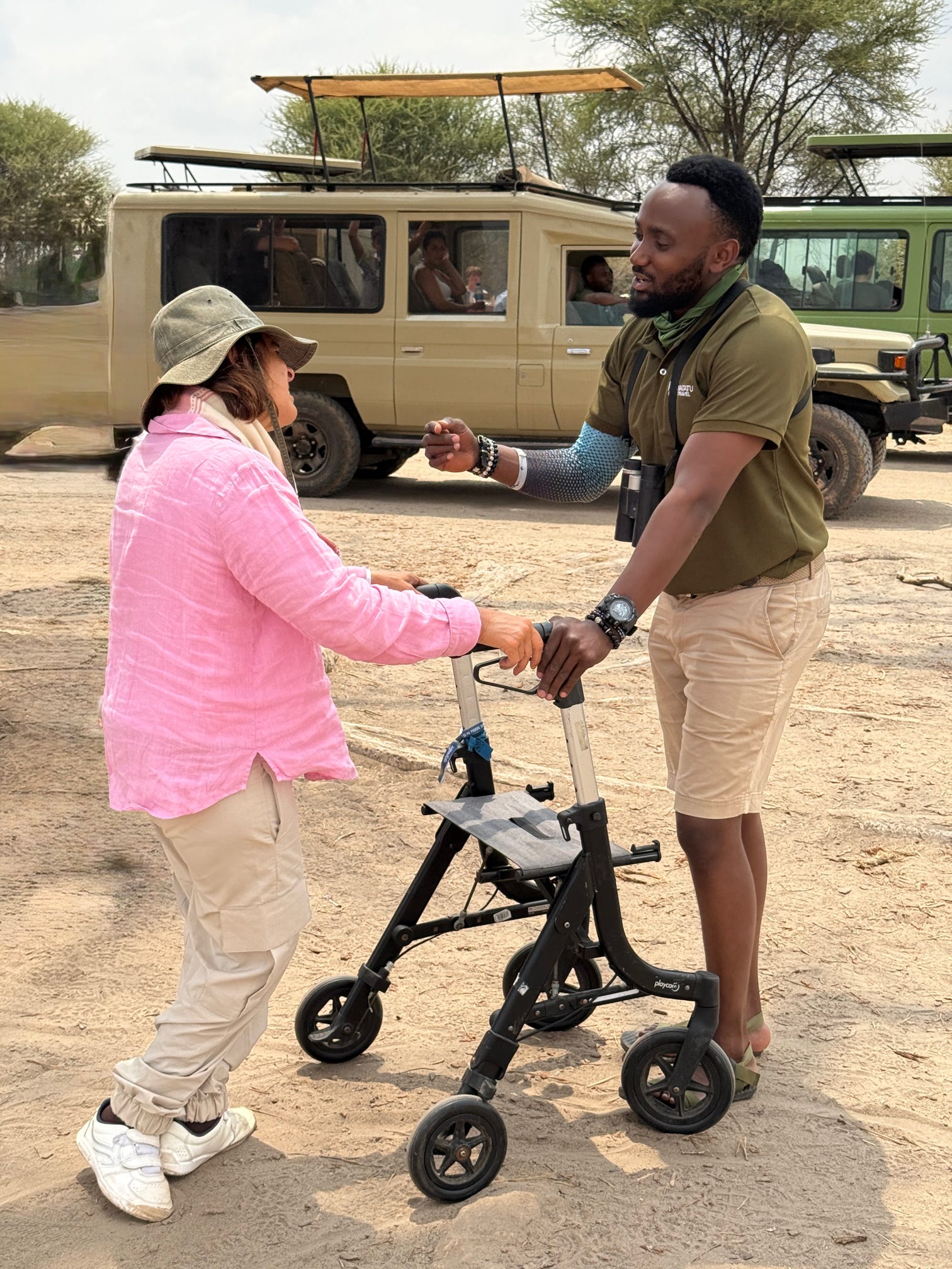 Guia de safari ajuda una turista amb caminador en una zona de descans de Tanzània